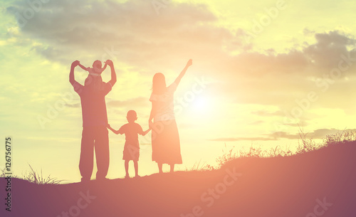 Happy family dancing on the road in the sunset time. Evening par