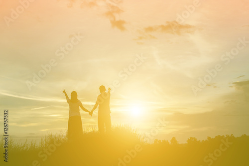 a silhouette of a man and woman holding hands with each other  w