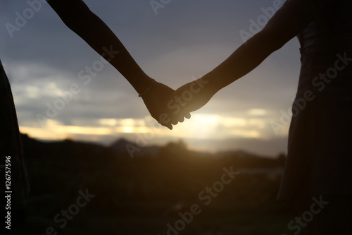  young couple holding hands. In Nature sunrise