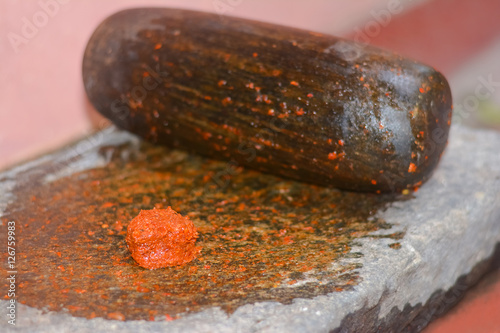 Traditional Sri Lankan way of grinding spices with the grinding stone. Before the electric blenders, the spices were painstakingly ground manually in all houses in Sri Lanka with the grinding stone photo