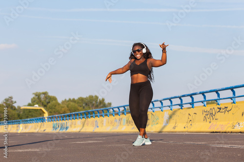 Young black woman dancing on the street © ginkgofoto
