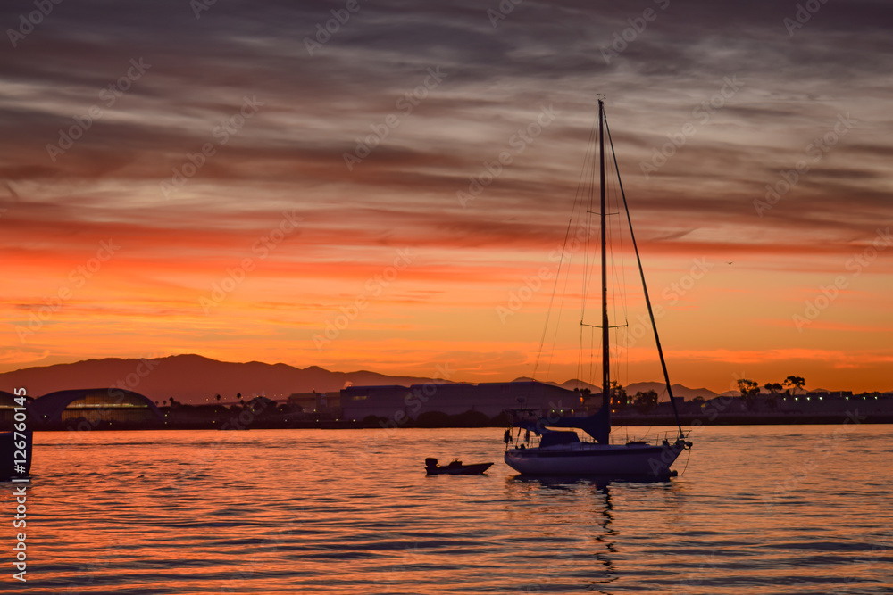Sailboat with the sunrise in a bay