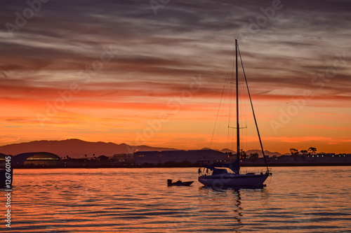 Sailboat with the sunrise in a bay