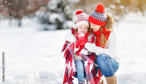 happy family mother and child on winter walk drinking tea