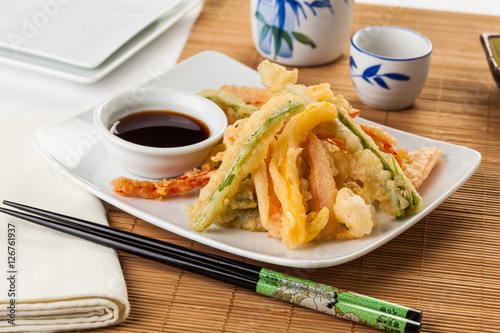 Tempura vegetables with soy sauce.