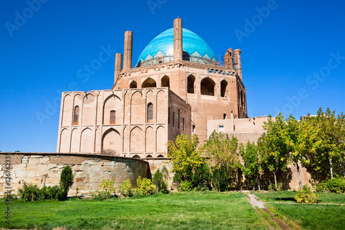 Green oasis with trees and historical 14 century blue domed mausoleum Dome of Soltaniyeh