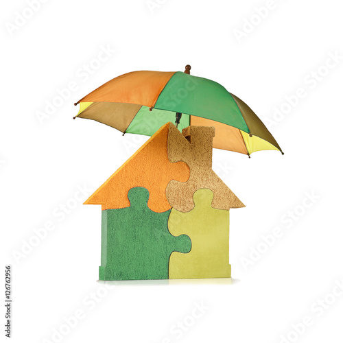 Canvastavla Casa puzzle colorata protetta da ombrello multicolore, isolata su fondo bianco