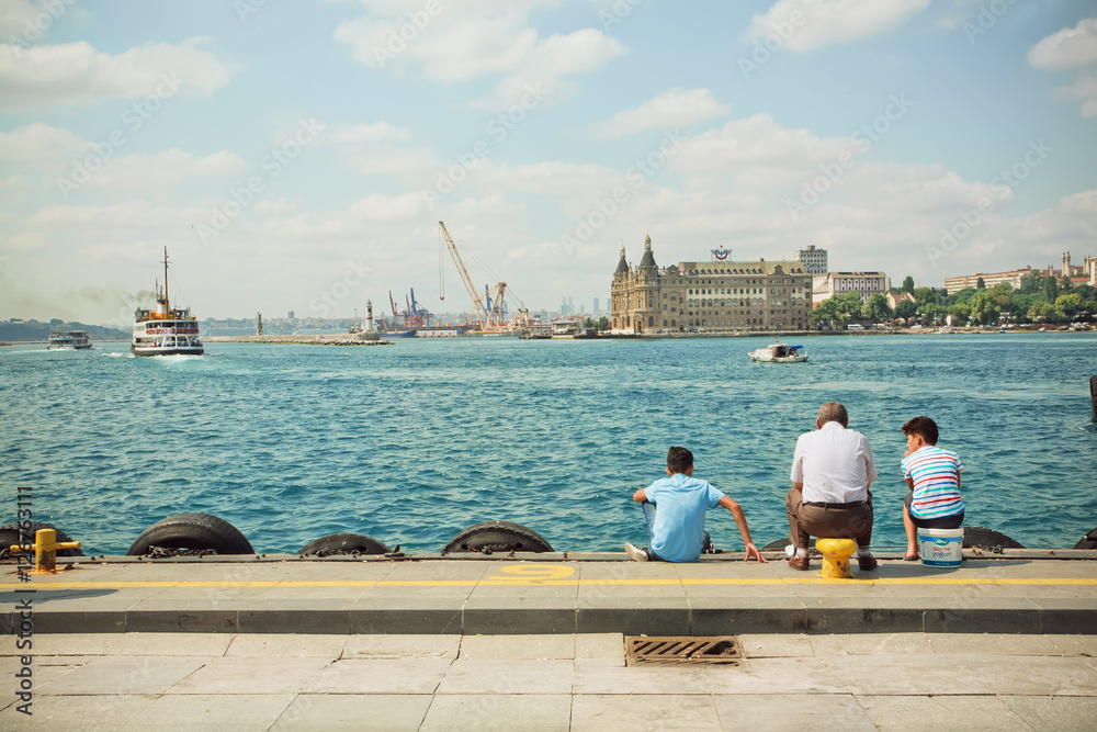 Grandfather and two grandsons looking into distance on Bosphorus Grandfather and two grandsons looking into distance on Bosphorus