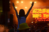 Girls with hands up dancing, singing and listening the music during concert show on summer music festival