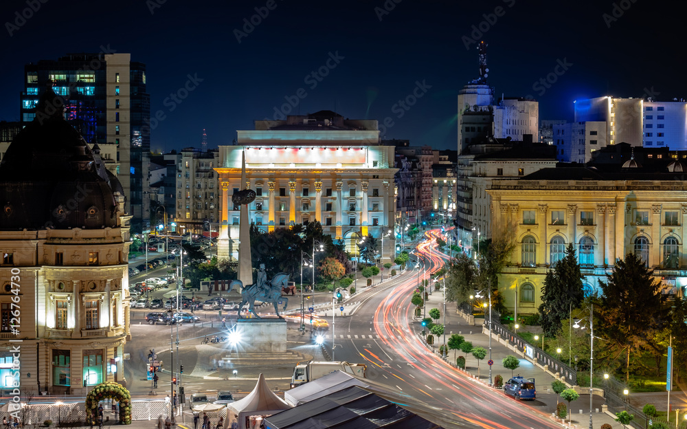 Fototapeta premium Long exposure shot of the Revolution Square,Victoria Avenue in Bucharest, Romania. Traffic and historical buildings