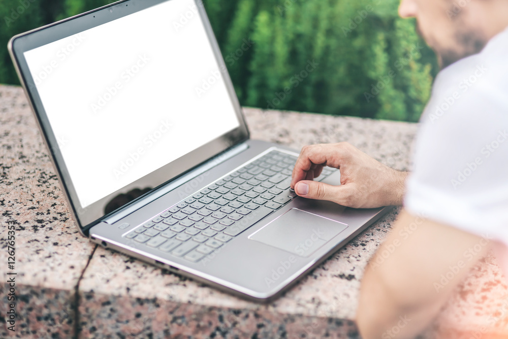 Man working on modern Laptop mockup with white blank screen. Close up of man's hands touching touchpad Man working on modern Laptop mockup with white blank screen. Close up of man's hands touching touchpad