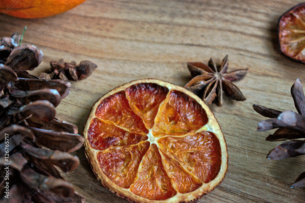 Dried orange slice and pine cones on a wooden table