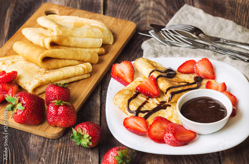 Fresh homemade crepes with strawberries and chocolate sauce