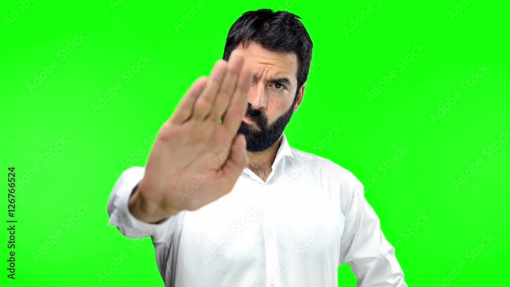 Man making stop sign on green screen chroma key