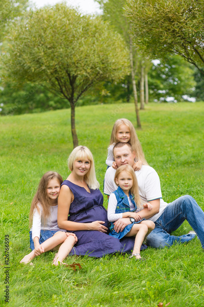 Young pregnant mother with her family in a park Young pregnant mother with her family in a park