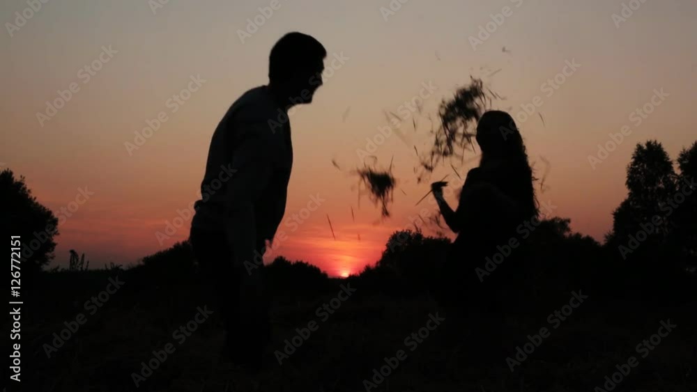 A boy and a girl couple silhouette hugging, playing, kissing during sunset A boy and a girl couple silhouette hugging, playing, kissing during sunset