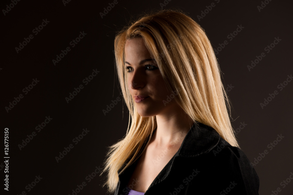 Portrait of a beautiful blonde woman over dark gray background