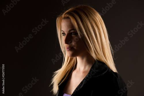 Portrait of a beautiful blonde woman over dark gray background