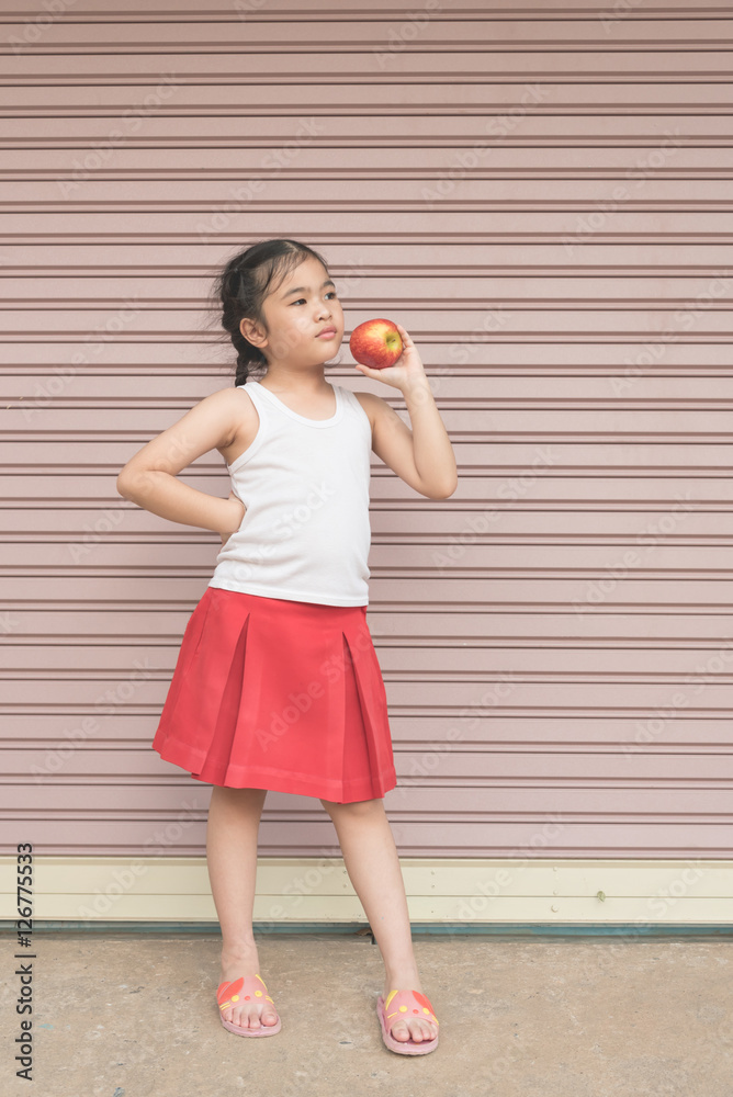 Little Asian girl enjoy eat an apple. Little Asian girl enjoy eat an apple.