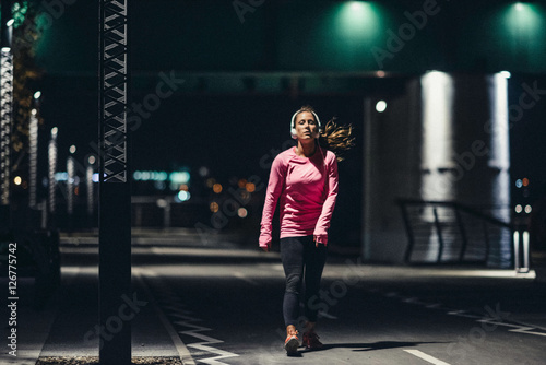 Late night jogging. . Female jogging late at night in the city 