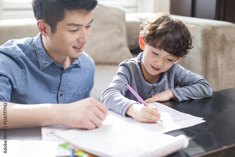 Young father helping son with homework Young father helping son with homework