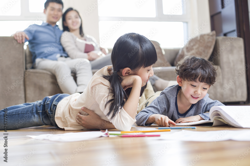 Happy siblings studying together at home Happy siblings studying together at home
