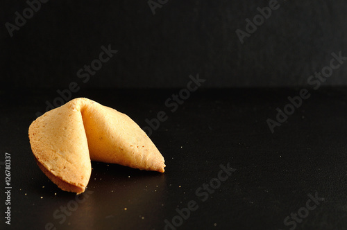 A fortune cookie isolated on a black background