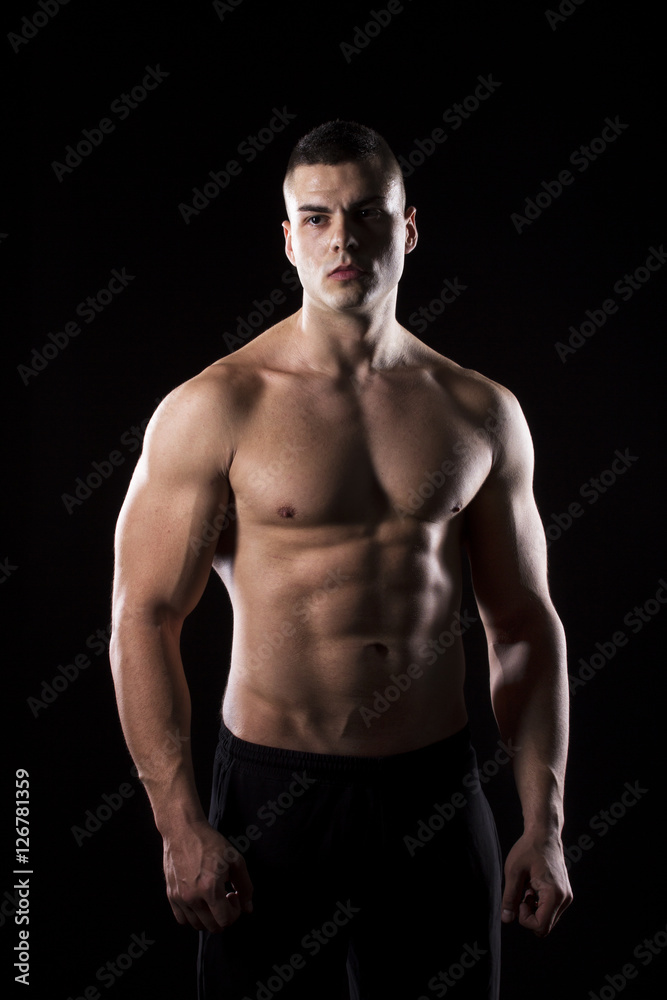Strong young man showing his muscles Strong young man showing his muscles