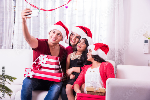 Photography Young happy indian or asian family of four taking a photo of themselves by smart
