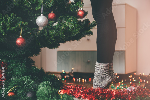 Obraz na plátně Woman decorating a christmas tree