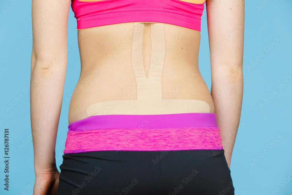 Woman with medical kinesio taping on back Woman with medical kinesio taping on back