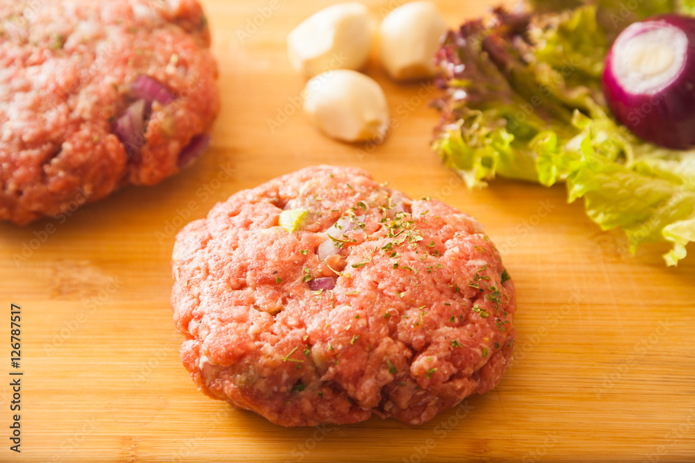 raw meat burger lies on a board raw meat burger lies on a board