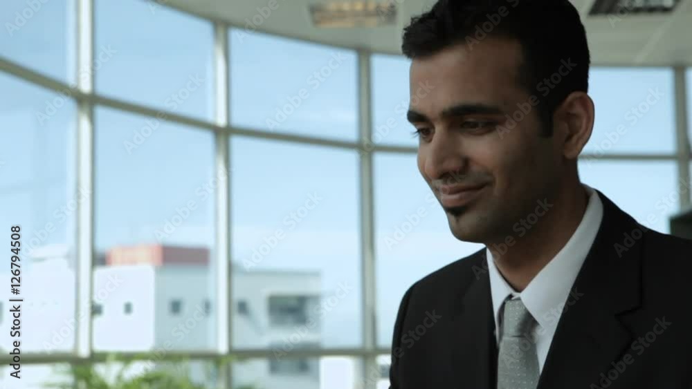 MS TU Businessman smiling and typing on laptop in office MS TU Businessman smiling and typing on laptop in office
