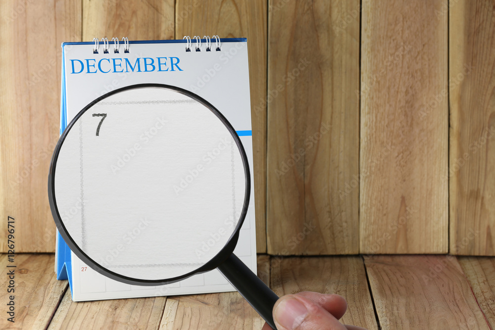 Magnifying glass in hand on calendar you can look Seventh day of Magnifying glass in hand on calendar you can look Seventh day of