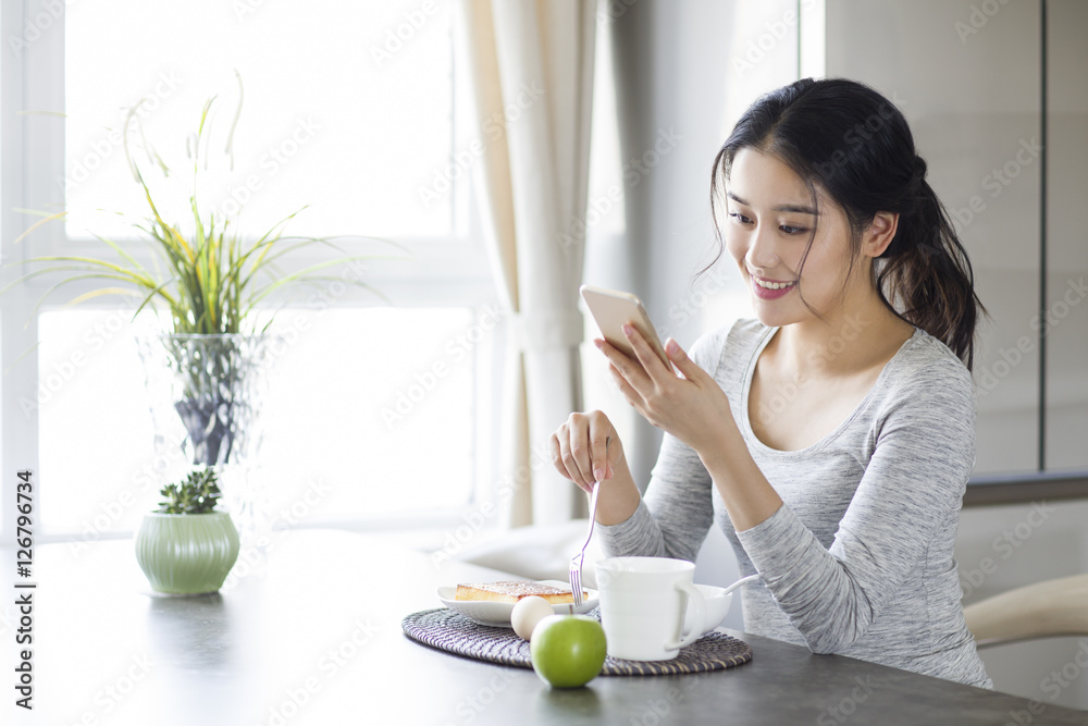 Young woman eating breakfast at home