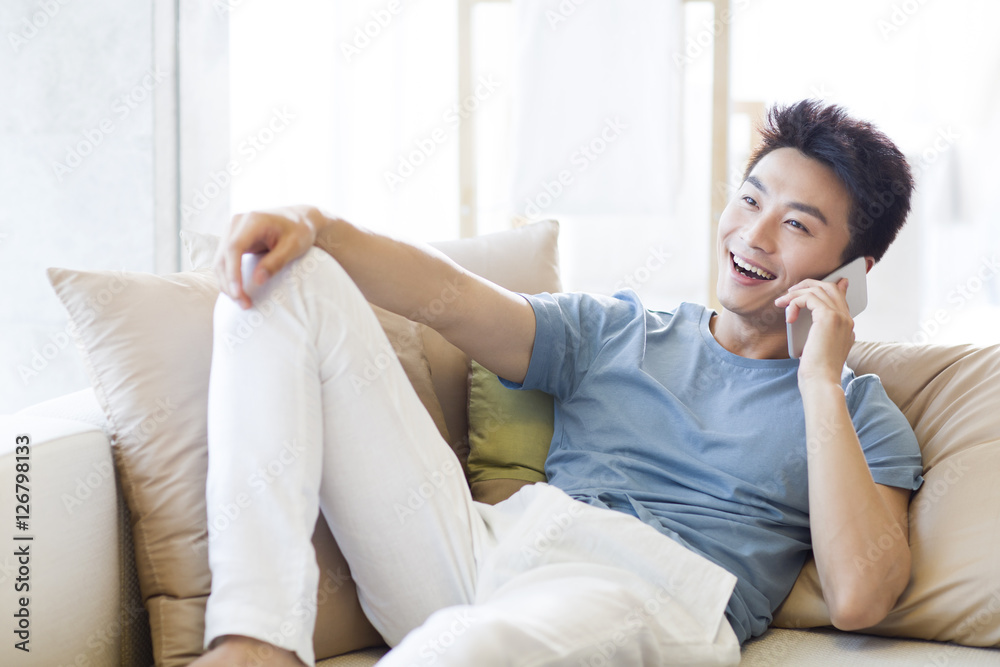 Young man talking on cell phone at home Young man talking on cell phone at home
