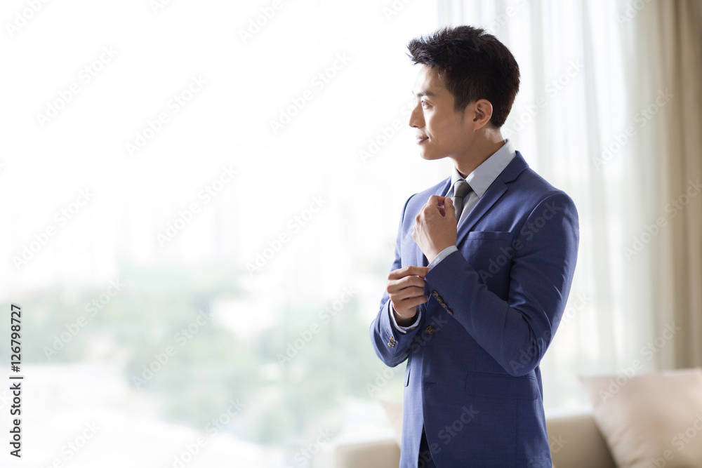Young businessman getting dressed in the morning Young businessman getting dressed in the morning