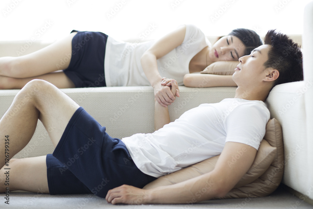 Young couple sleeping in living room Young couple sleeping in living room