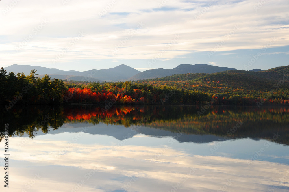 Autumn mountain and colorful forest reflected in tranquil lake
