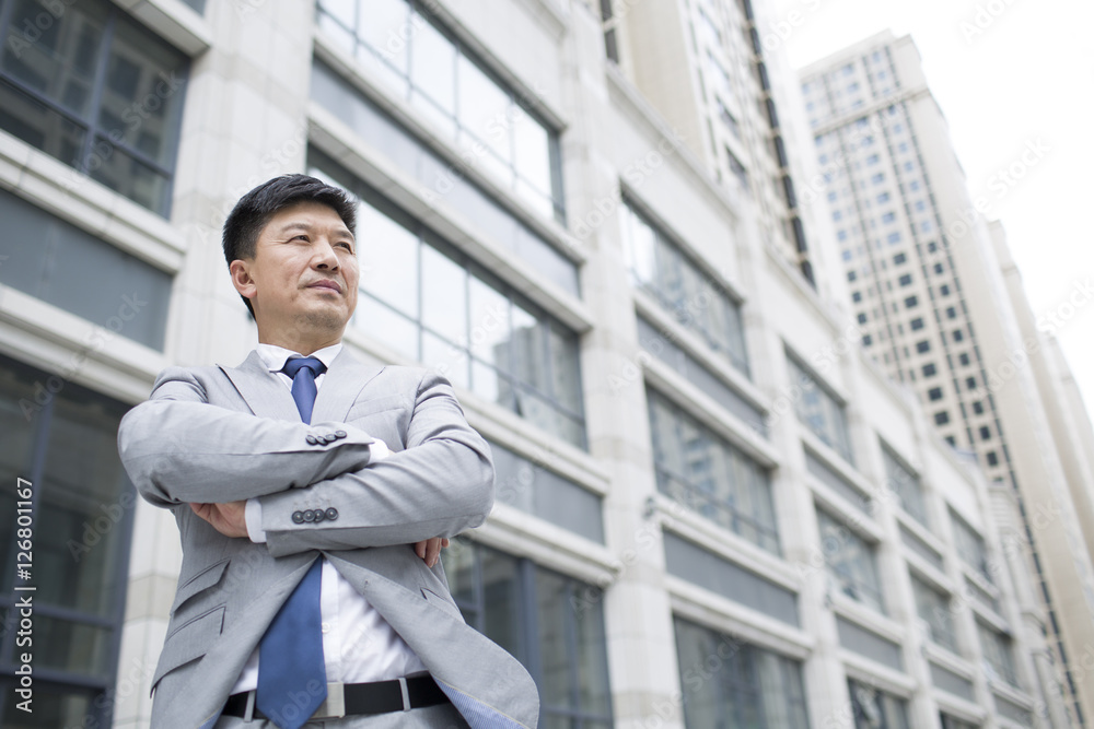 Confident businessman in front of skyscraper Confident businessman in front of skyscraper