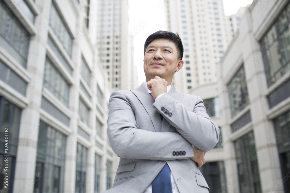 Confident businessman in front of skyscraper Confident businessman in front of skyscraper