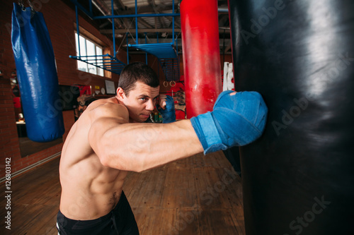 Boxer training with punching bag. © Nomad_Soul