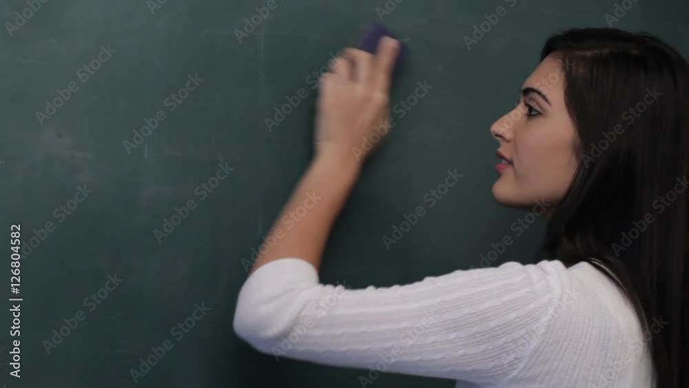MS Woman erasing mathematical formula from blackboard MS Woman erasing mathematical formula from blackboard