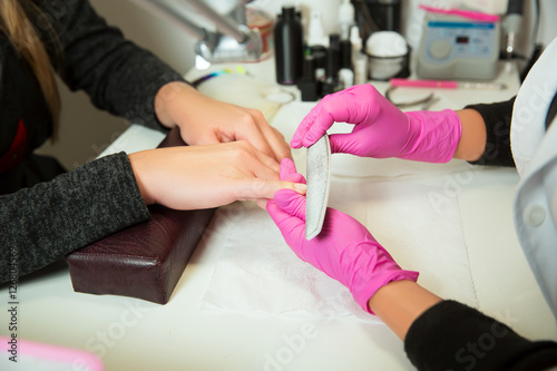 Manicure specialist works with nailfile. © Nomad_Soul