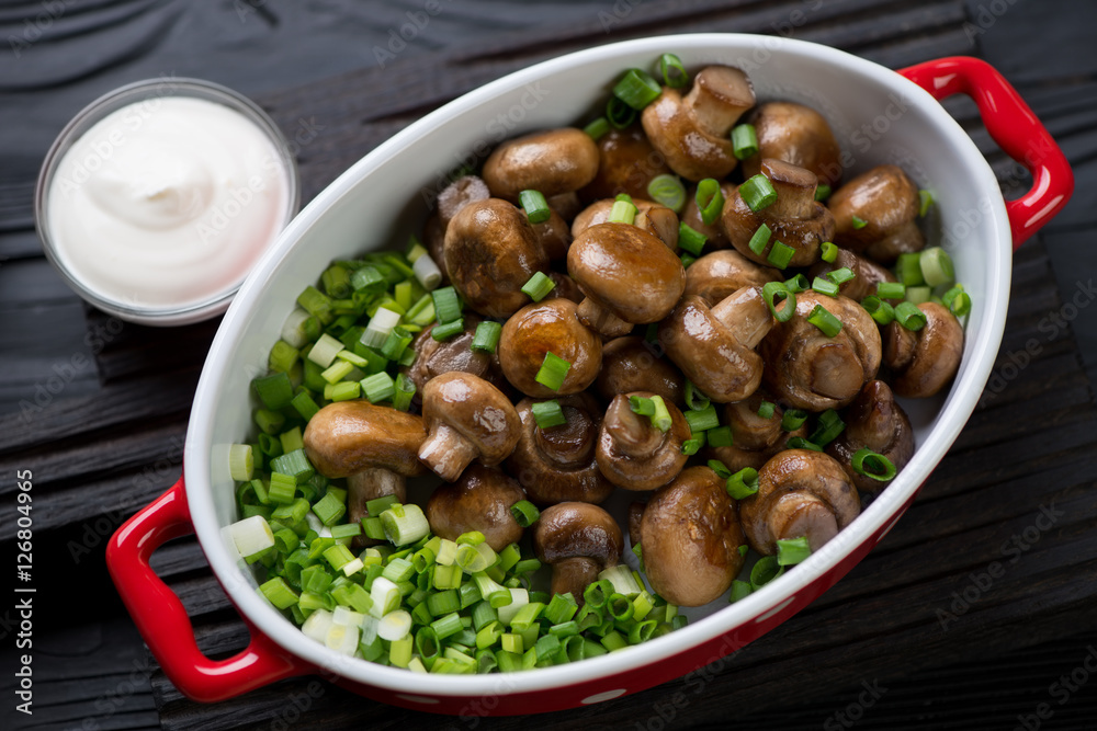 Closeup of roasted champignons served with green onion in a bowl Closeup of roasted champignons served with green onion in a bowl