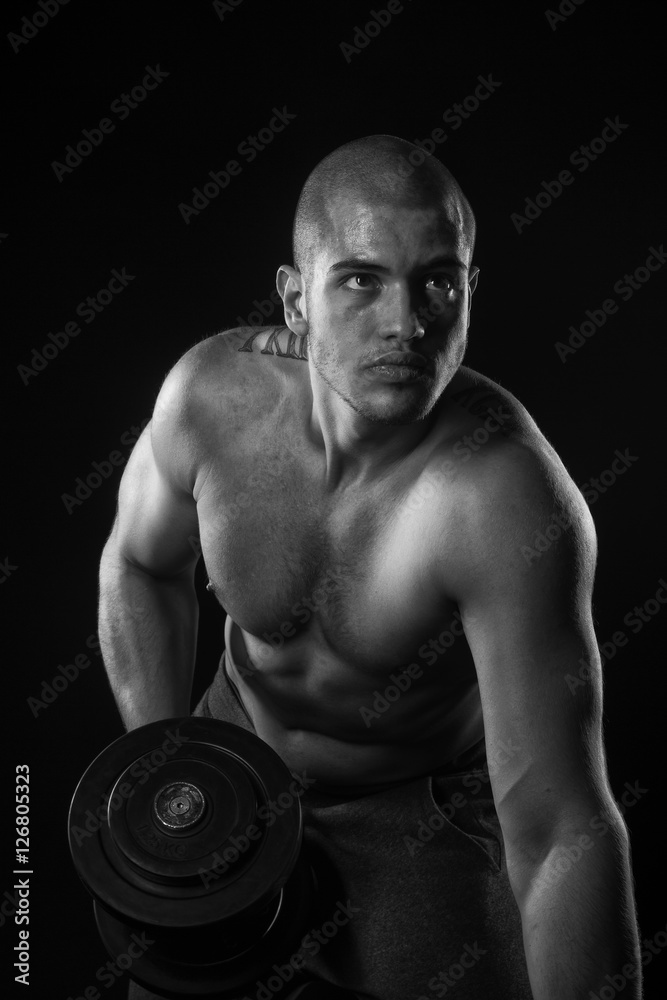 Strong young man with weight on his hand Strong young man with weight on his hand