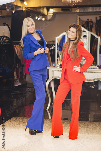 Women posing in red and blue suits