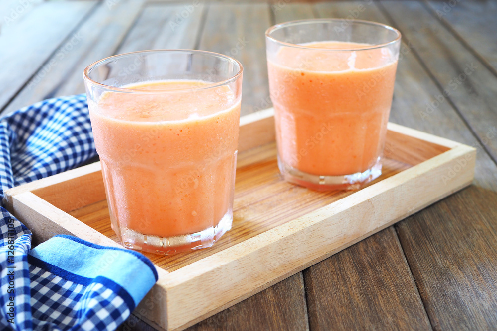 Close up of papaya smoothies on a wooden tray. Close up of papaya smoothies on a wooden tray.