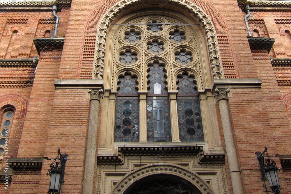 Brick red wall with a window in the Gothic style