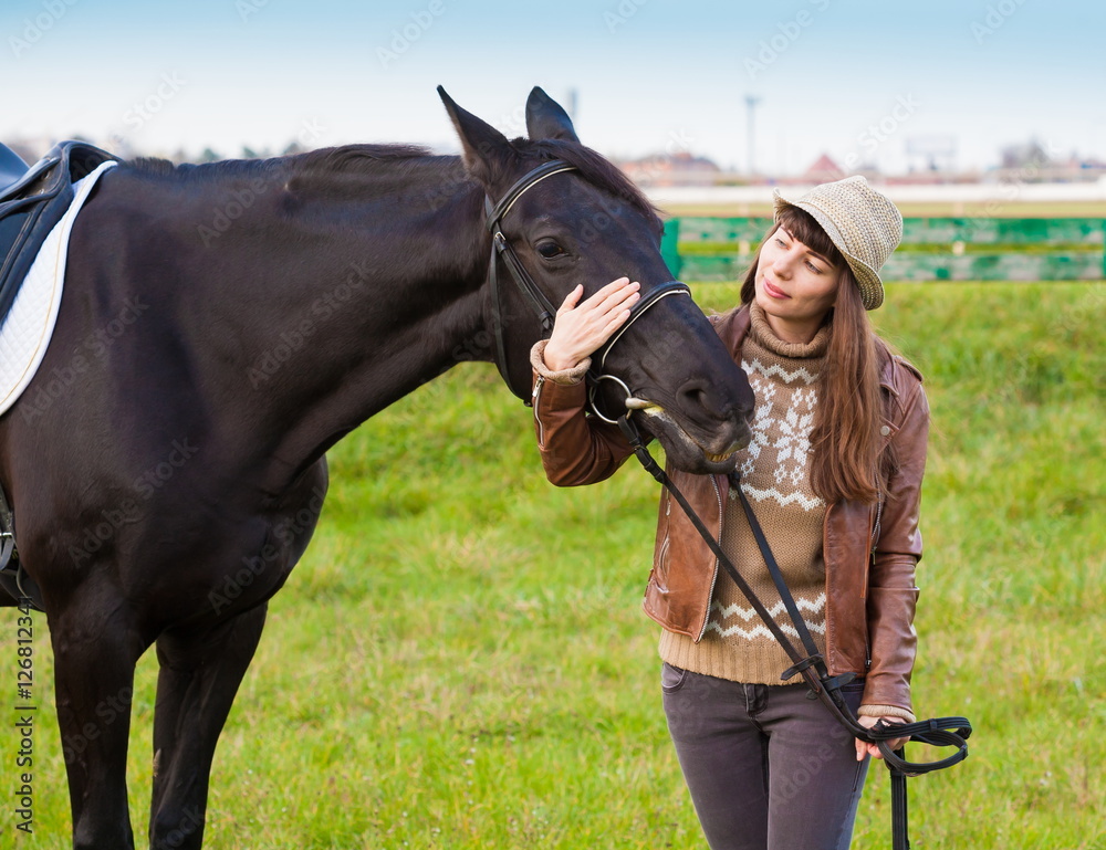 Obraz premium Woman and horse, beige pullover, leather jacket, jeans, hat, cl